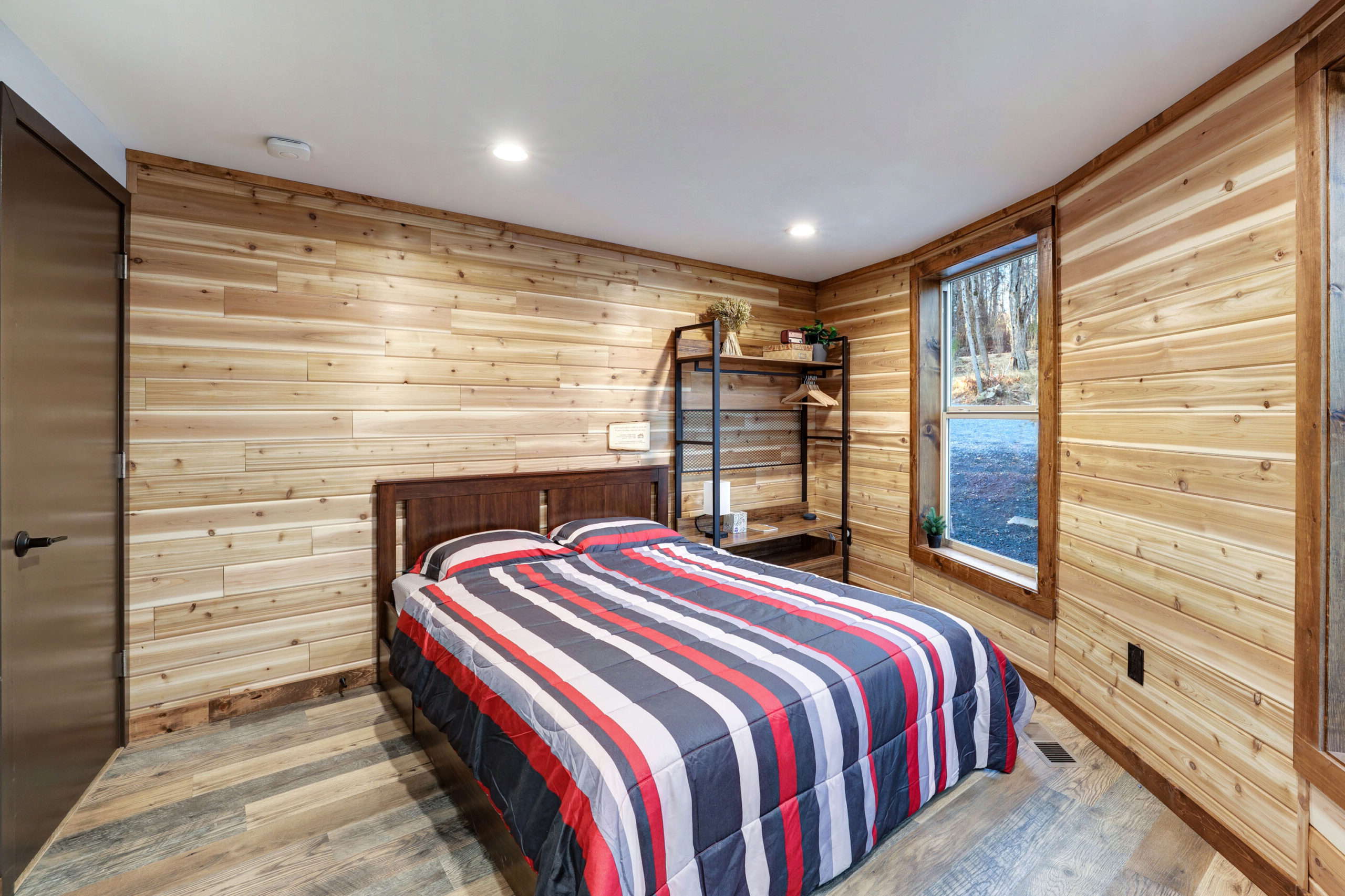 Bedroom #1 with storage, hangers, shelves, comfortable queen size bed, height-adjustable pillows, and USB A and C charging ports. -- Skyline Yurt, Skyline Cabin